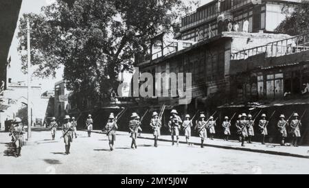 Fanteria britannica in pattuglia antisommossa a Peshawar durante le manifestazioni contro il governo coloniale britannico in India nel 1930. Foto Stock