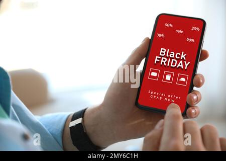 Black Friday. Uomo che acquista online con lo smartphone, primo piano Foto Stock