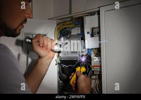 Elettricista che riceve scosse elettriche durante il lavoro, primo piano Foto Stock