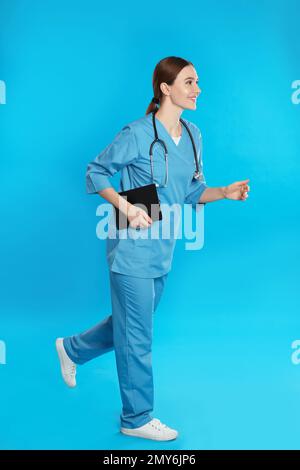 Medico con appunti e stetoscopio in esecuzione su sfondo blu Foto Stock