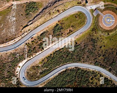 Vista aerea della strada tortuosa. Splendida scena mattutina di strada asfaltata. Eliporto per elicotteri di emergenza. Vista aerea dell'eliporto per l'elicottero di emergenza Foto Stock