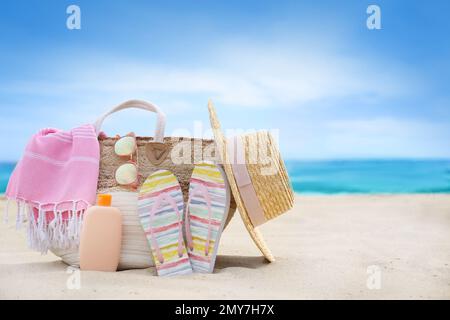 Diversi oggetti di stile spiaggia sulla sabbia vicino al mare Foto Stock