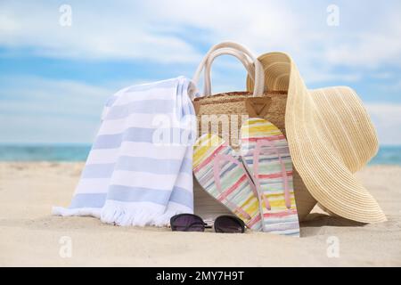 Diversi oggetti di stile spiaggia sulla sabbia vicino al mare Foto Stock