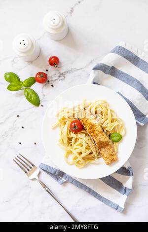 Spaghetti senza glutine con salmone alla griglia in formaggio cremoso su sfondo marmoreo. Vista dall'alto. Foto Stock