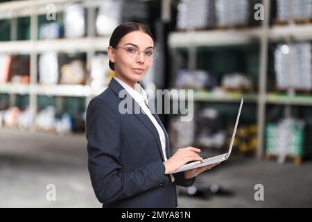 Concetto di commercio all'ingrosso e di logistica. Manager che utilizza il laptop in magazzino Foto Stock
