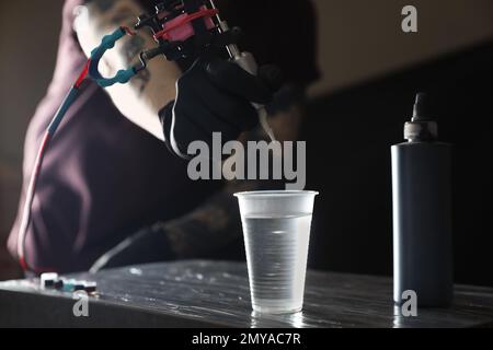 Tatuaggio artista pulitore ago a tavola, primo piano Foto Stock
