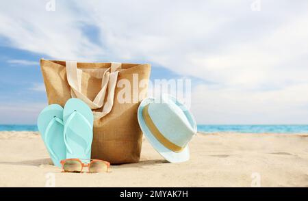 Diversi oggetti di stile spiaggia sulla sabbia vicino al mare Foto Stock