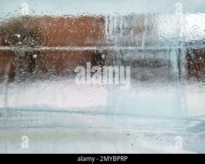 Primo piano di uno strato di ghiaccio gelido sopra una parete di mattoni marroni Foto Stock