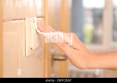 Donna che usa carta tissue per accendere la luce all'interno, primo piano Foto Stock