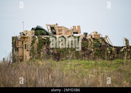 Primo piano di un veicolo di pattuglia protetto da Mastiff dell'esercito britannico sotto una rete verde di mimetizzazione Foto Stock