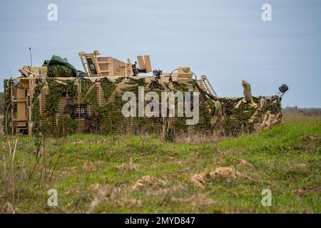 Primo piano di un veicolo di pattuglia protetto da Mastiff dell'esercito britannico sotto una rete verde di mimetizzazione Foto Stock