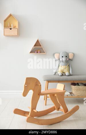 Cavallo a dondolo in legno nella bella camera per bambini. Design elegante Foto Stock