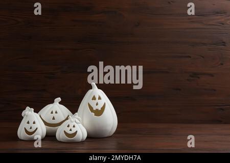 Portacandele bianco a forma di zucca su sfondo di legno, spazio per il testo. Decorazione di Halloween Foto Stock