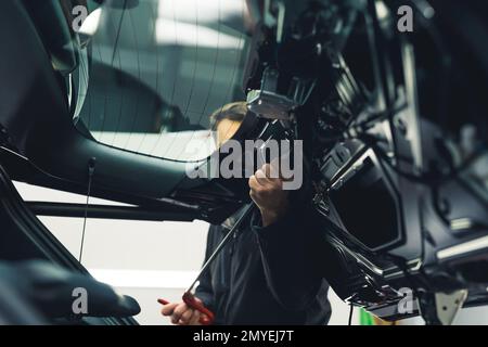 Carrozzeria della vettura lavora con la tecnologia di riparazione delle ammaccature senza verniciatura. All'interno del carrello POV. Processo di dettaglio meccanico e dell'auto. Foto di alta qualità Foto Stock