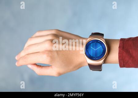 Donna con orologio intelligente con orologio analogico viso pelle, primo piano Foto Stock