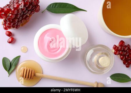 Composizione con maschera naturale fatta in casa, melograno e ingredienti su sfondo bianco, vista dall'alto Foto Stock