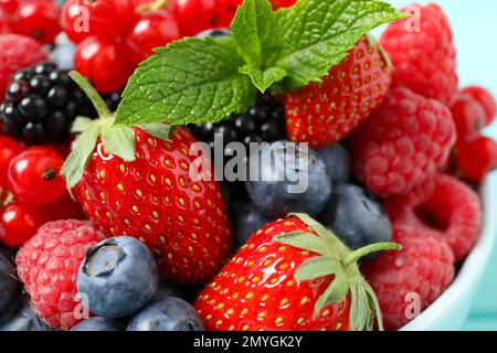 Mescolare le diverse bacche fresche e la menta nel recipiente, primo piano Foto Stock