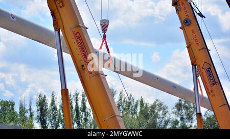 Varsavia, Polonia. 17 maggio 2021. Diversi ganci per gru con cinghie trattengono il tubo isolato Foto Stock