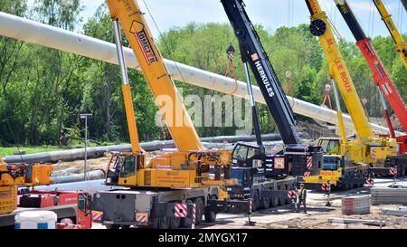 Varsavia, Polonia. 17 maggio 2021. Diversi ganci per gru con cinghie trattengono il tubo isolato Foto Stock