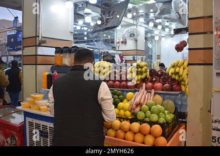 Un uomo che sceglie frutta fresca da una bancarella di mercato a Duhok, nel nord dell'Iraq Foto Stock