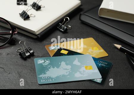 Carte di credito e cancelleria su sfondo nero Foto Stock