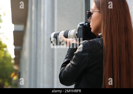 Detective privato con macchina fotografica spionaggio sulla strada della città Foto Stock