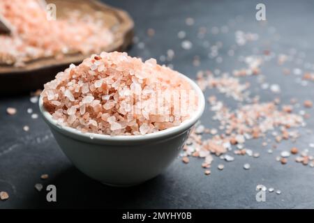 Sale himalaya rosa in ciotola di ceramica su tavola nera Foto Stock