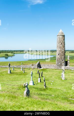 Iroquoian chiesa, monastero in rovina, croci celtiche, cimitero, tempio Finghin e torre rotonda con guglia, Clonmacnoise monastero, fiume Shannon, contea Foto Stock