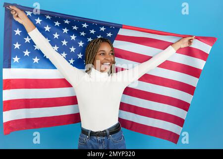 Donna africana felice che alza una bandiera americana Foto Stock