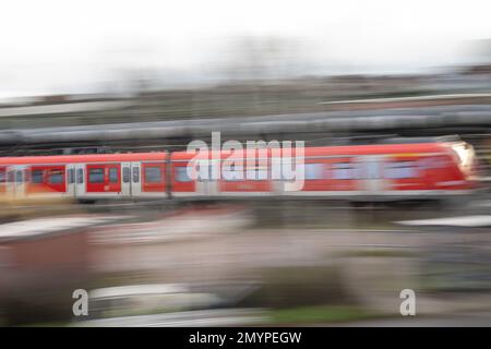 Bischofsheim, Germania. 16th Jan, 2023. Un treno suburbano da Hanau a Mainz e Wiesbaden è in funzione su binari vicino alla stazione di Mainz-Bischofsheim. (Effetto di cancellazione a causa di una lunga esposizione) Credit: Sebastian Gollnow/dpa/Alamy Live News Foto Stock