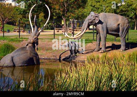 Un'illustrazione di una scena preistorica, dove un mammut completamente è bloccato nel catrame, è rappresentata ai box di catrame di la Brea a Los Angeles Foto Stock