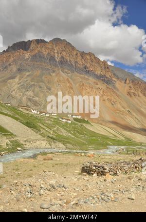 Vista di un villaggio vicino a una bella montagna rocciosa con un fiume che scorre nel modo di Darcha-Padum strada, Ladakh, INDIA. Foto Stock