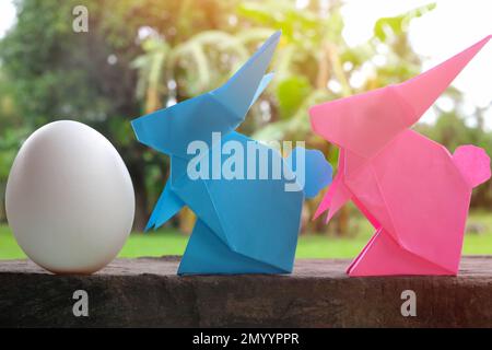Origami di carta coniglietto di coniglio colorato e carino con uovo in giardino. Buon concetto di festa di Pasqua. Foto Stock