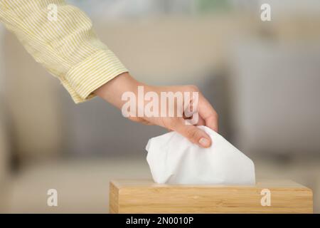 Donna che prende carta fazzoletto da interno supporto, primo piano Foto Stock