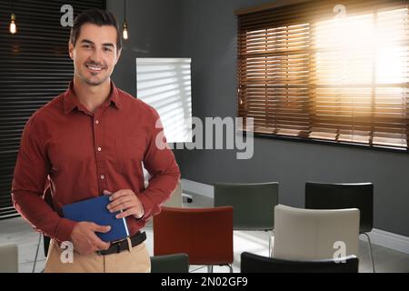 Giovane insegnante in attesa di studenti in classe Foto Stock