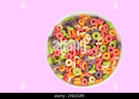 Deliziosi e nutrienti cicli di cereali alla frutta multicolori aromatizzati su sfondo bianco, sana e divertente aggiunta alla colazione per bambini Foto Stock