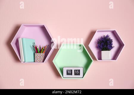 Ripiani a forma esagonale sulla parete rosa. Design degli interni Foto Stock