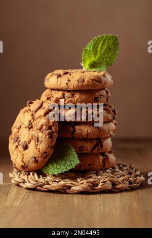 Biscotti al cioccolato appena sfornati con menta su un tavolo di legno. Foto Stock