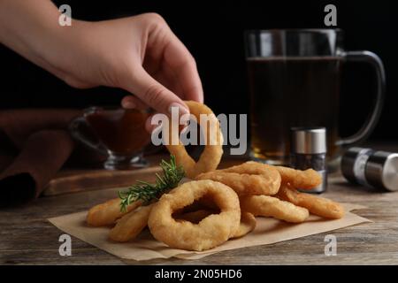 Donna che mangia anelli di cipolla fritti con salsa a tavola Foto stock -  Alamy