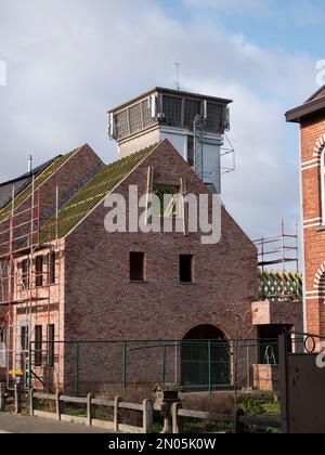 Un nuovo edificio incompiuto in una strada con impalcature accanto ad esso Foto Stock