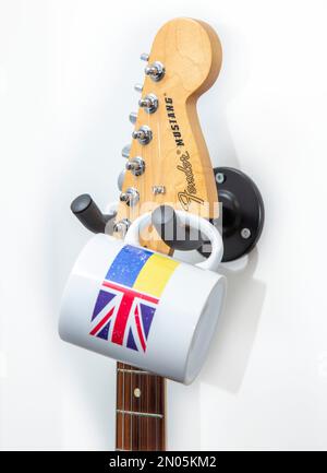 Sostegno all'Ucraina. I musicisti sostengono il sollievo ucraino. Chitarra e tazza di caffè. Aiuti all'Ucraina, DEC, bandiera della Croce Rossa Funds.Ukraine, Union Jack Foto Stock