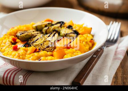 Risotto di zucca con germogli di Bruxelles arrosto e riduzione dell'aceto balsamico Foto Stock