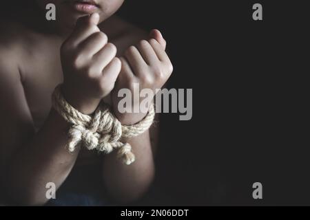 Ragazzo vittima con le mani legate con corda in stress emotivo e dolore, rapito, abusato, ostaggio, smettere di abusare della violenza, Bambini violenza e abusi Foto Stock