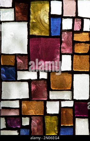 Struttura di una finestra astratta di vetro colorato con forme geometriche e colorate in una chiesa Foto Stock