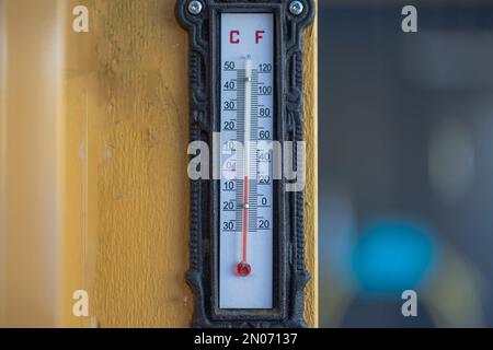 Vista ravvicinata del termometro per esterni su colonna di legno giallo nella giornata invernale. Svezia. Foto Stock