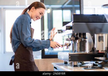 la signora della caffetteria sta preparando le attrezzature per l'apertura del negozio per servire le bevande del caffè ai clienti con servizio standard, pulizia e int Foto Stock