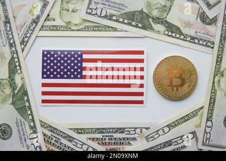 Golden bitcoin BTC e bandiera degli Stati Uniti d'America USA sul tavolo. Foto Stock