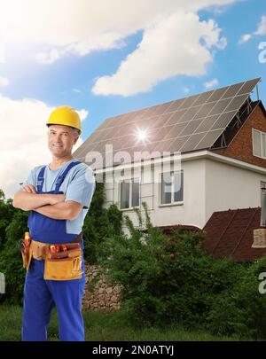 Ingegnere vicino casa con pannelli solari installati. Fonte di energia alternativa Foto Stock