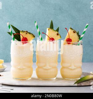 Cocktail tropicale pina colada o mocktail in un bicchiere tiki con ananas e ciliegia Foto Stock