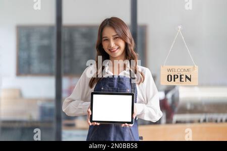 ritratto di una donna che indossa un grembiule con un tablet digitale e uno schermo bianco. Cameriere che tiene una scheda touch screen con spazio per la copia per il Foto Stock